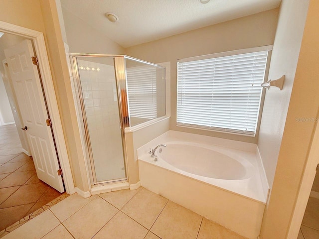 full bathroom with tile patterned floors, a bath, and a stall shower