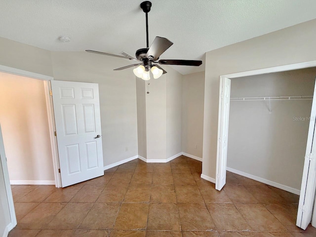 unfurnished bedroom with a textured ceiling, a closet, tile patterned flooring, and ceiling fan