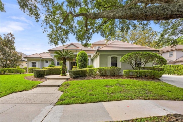 307 Running Wind Ln, Maitland, FL 32751 - mediterranean / spanish house featuring a tiled roof, a front lawn, and stucco siding