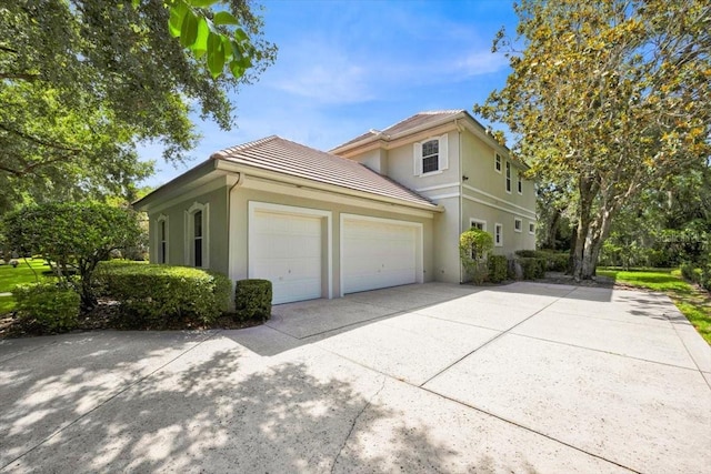 307 Running Wind Ln, Maitland, FL 32751 - view of home's exterior featuring driveway, a garage, stucco siding, and a tile roof
