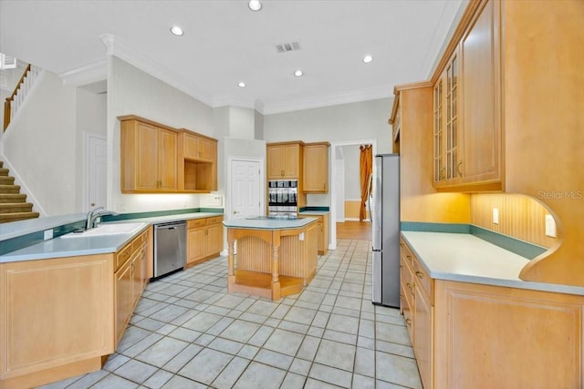 307 Running Wind Ln, Maitland, FL 32751 - kitchen with appliances with stainless steel finishes, a kitchen island, ornamental molding, light tile patterned floors, and glass insert cabinets