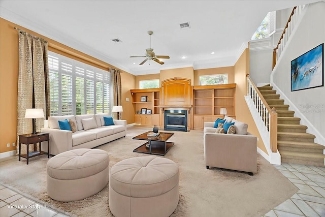 307 Running Wind Ln, Maitland, FL 32751 - living area with stairs, ceiling fan, ornamental molding, a glass covered fireplace, and light tile patterned floors