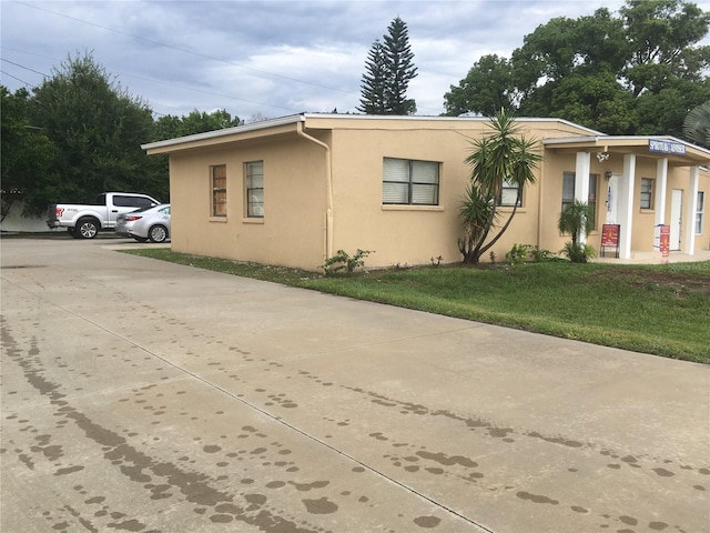 10 S Semoran Blvd S, Orlando, FL 32822 - view of front of house with stucco siding, a front yard, and driveway