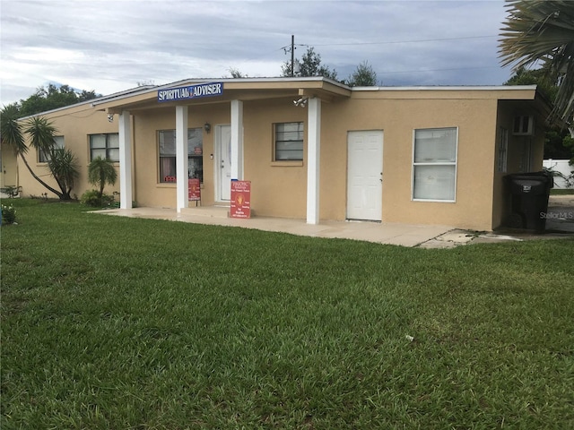 10 S Semoran Blvd S, Orlando, FL 32822 - back of house with stucco siding and a lawn