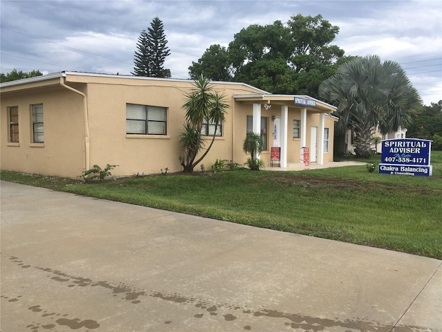 10 S Semoran Blvd S, Orlando, FL 32822 - view of front of house featuring stucco siding and a front lawn
