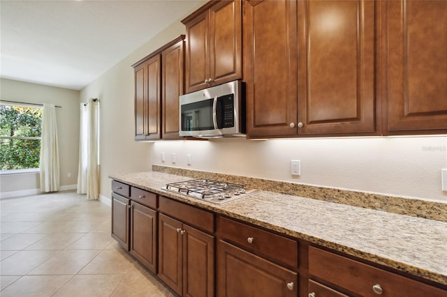 207 Spalding Way, Deland, FL 32724 - kitchen featuring appliances with stainless steel finishes, light stone countertops, and light tile patterned floors