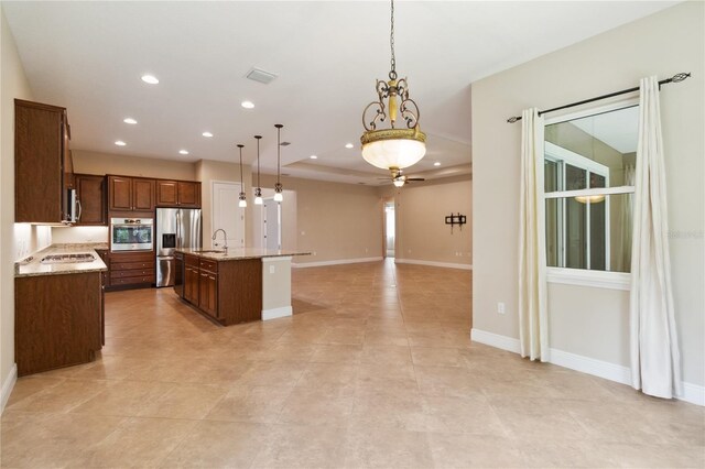 207 Spalding Way, Deland, FL 32724 - kitchen with stainless steel appliances, ceiling fan, an island with sink, hanging light fixtures, and light stone counters