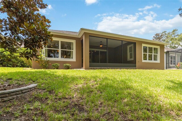 207 Spalding Way, Deland, FL 32724 - rear view of house featuring stucco siding, a yard, and a sunroom