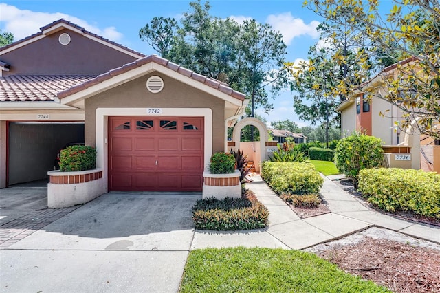 7742 Sugar Bend Dr Unit 7742, Orlando, FL 32819 - view of front of house featuring driveway, stucco siding, a tile roof, and a garage