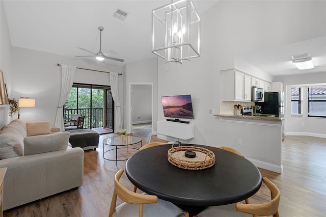 7742 Sugar Bend Dr Unit 7742, Orlando, FL 32819 - dining space featuring light wood-style flooring, ceiling fan, and a towering ceiling