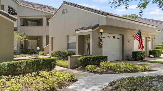 165 Durham Pl Unit 165, Longwood, FL 32779 - view of front of property with stucco siding, a tiled roof, concrete driveway, and a garage