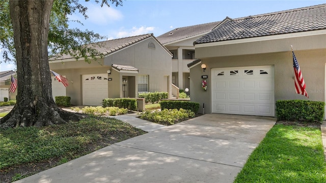165 Durham Pl Unit 165, Longwood, FL 32779 - view of front facade featuring a tiled roof, stucco siding, concrete driveway, and a garage