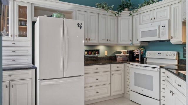 165 Durham Pl Unit 165, Longwood, FL 32779 - kitchen with white appliances, dark stone counters, light tile patterned floors, and white cabinets