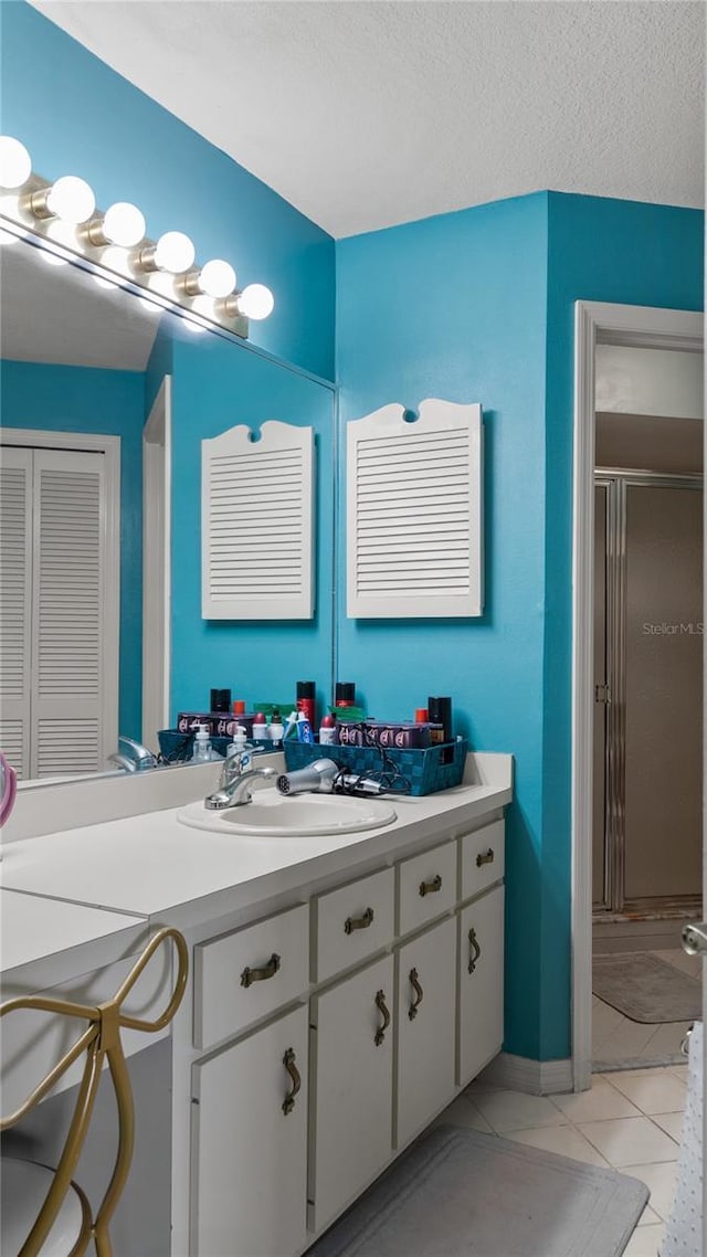 165 Durham Pl Unit 165, Longwood, FL 32779 - bathroom featuring a stall shower, vanity, tile patterned flooring, a closet, and a textured ceiling