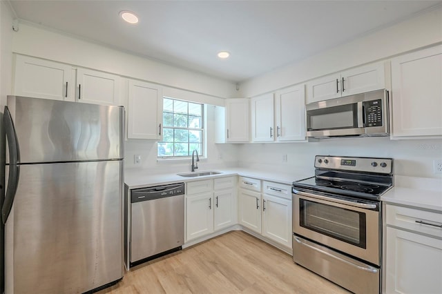 4800 Reginald Rd, Orlando, FL 32829 - kitchen with appliances with stainless steel finishes, white cabinets, light wood finished floors, and recessed lighting