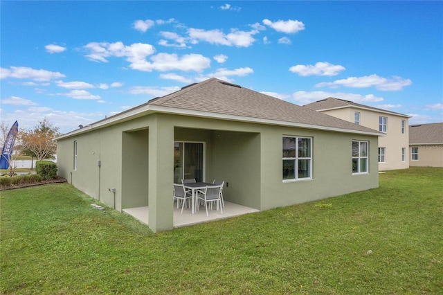 1902 Walnut Creek Dr, Kissimmee, FL 34744 - rear view of house with stucco siding, a patio, and a yard