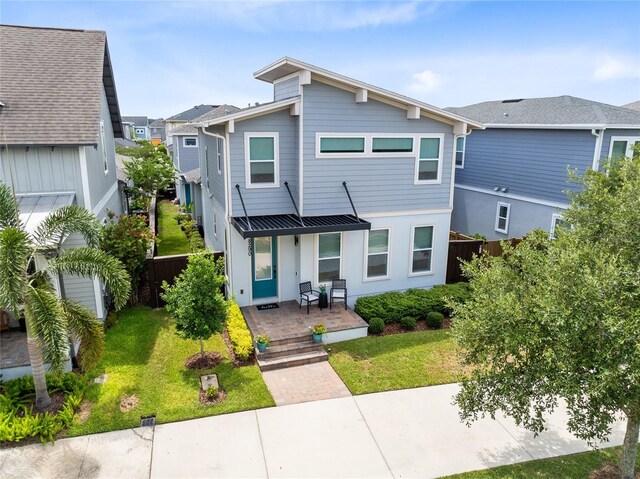 8290 Nemours Pkwy, Orlando, FL 32827 - rear view of house with a standing seam roof, a metal roof, covered porch, and a residential view