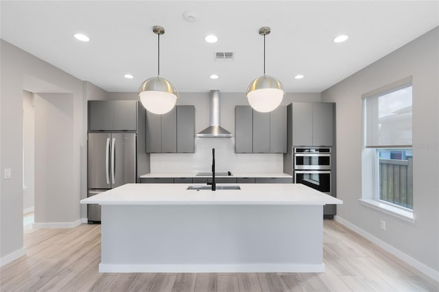 8290 Nemours Pkwy, Orlando, FL 32827 - kitchen featuring wall chimney exhaust hood, stainless steel appliances, gray cabinets, light countertops, and an island with sink