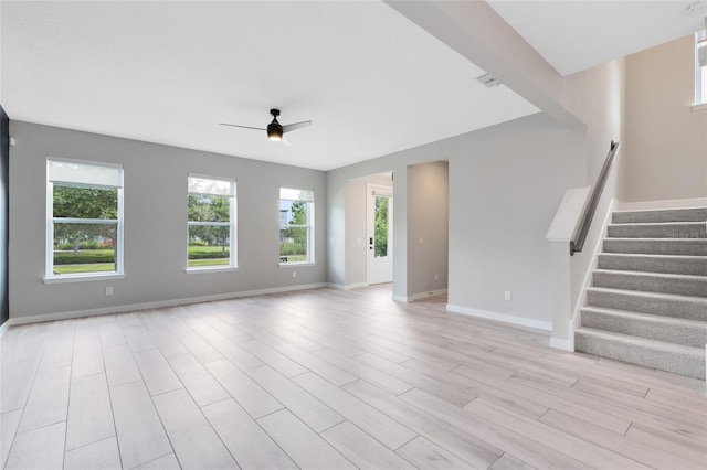 8290 Nemours Pkwy, Orlando, FL 32827 - unfurnished living room featuring a ceiling fan, stairs, and light wood-type flooring