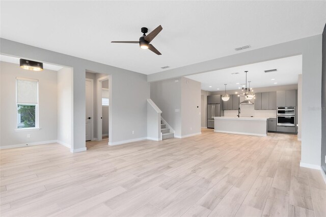 8290 Nemours Pkwy, Orlando, FL 32827 - unfurnished living room with light wood-style floors, stairway, ceiling fan, and recessed lighting