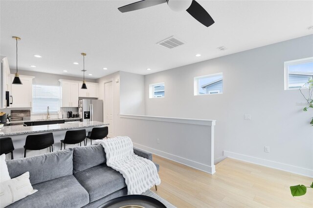8290 Nemours Pkwy, Orlando, FL 32827 - living room featuring light wood-style floors, plenty of natural light, a ceiling fan, and recessed lighting