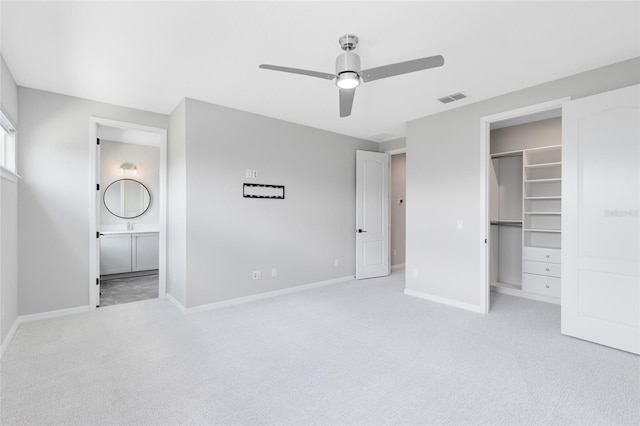 8290 Nemours Pkwy, Orlando, FL 32827 - unfurnished bedroom with light carpet, a walk in closet, a closet, connected bathroom, and a ceiling fan