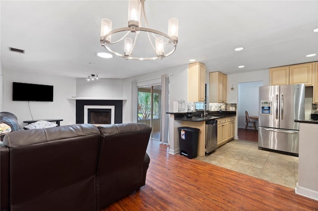 3220 Cardigan Ct, Orlando, FL 32812 - living room with a chandelier, recessed lighting, light wood finished floors, and a fireplace