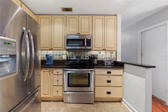 3220 Cardigan Ct, Orlando, FL 32812 - kitchen with appliances with stainless steel finishes, tasteful backsplash, light brown cabinetry, and dark stone counters