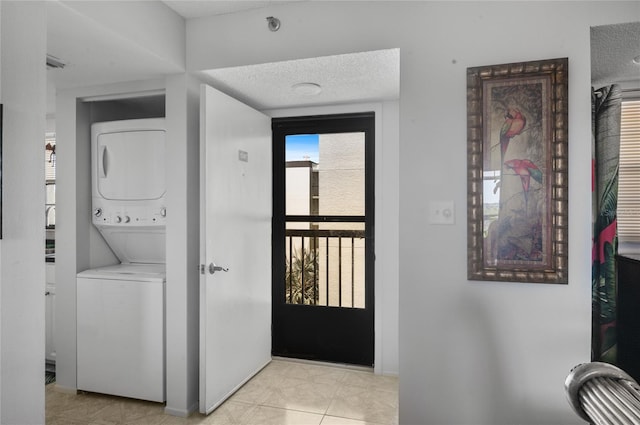 9860 62nd Ter N Unit 1047, Saint Petersburg, FL 33708 - washroom featuring stacked washer / drying machine, a textured ceiling, and light tile patterned flooring