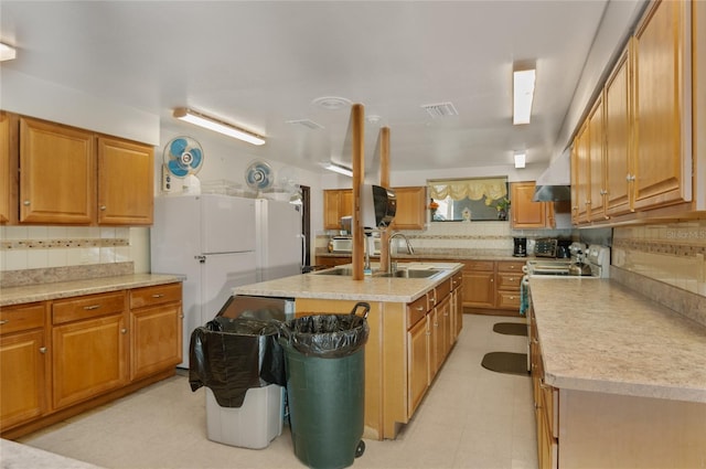9860 62nd Ter N Unit 1047, Saint Petersburg, FL 33708 - kitchen with tasteful backsplash, light countertops, a center island with sink, and brown cabinetry