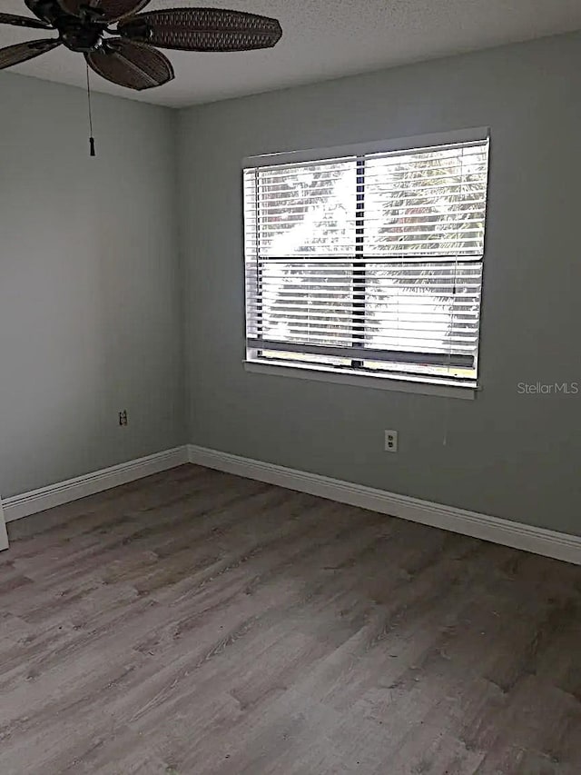 225 S Tropical Trl Unit 402, Merritt Island, FL 32952 - empty room with ceiling fan, wood finished floors, and healthy amount of natural light