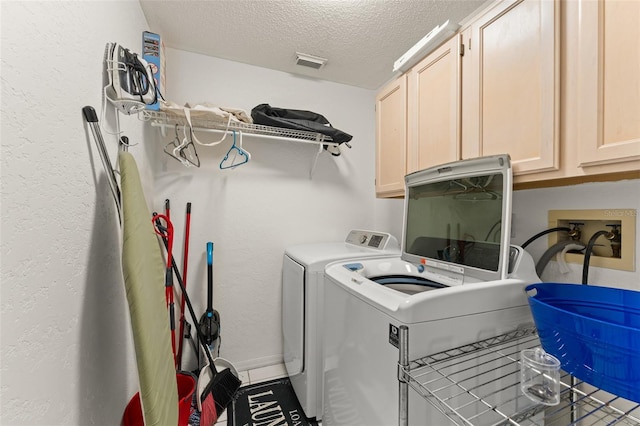 7764 Indian Ridge Trl N, Kissimmee, FL 34747 - laundry area with washing machine and clothes dryer, cabinet space, a textured ceiling, and a textured wall