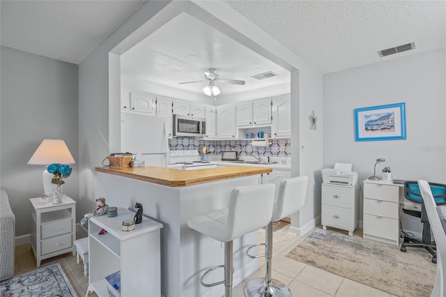 11923 Boynton Ln Unit B, New Port Richey, FL 34654 - kitchen with white appliances, open shelves, a textured ceiling, tasteful backsplash, and ceiling fan
