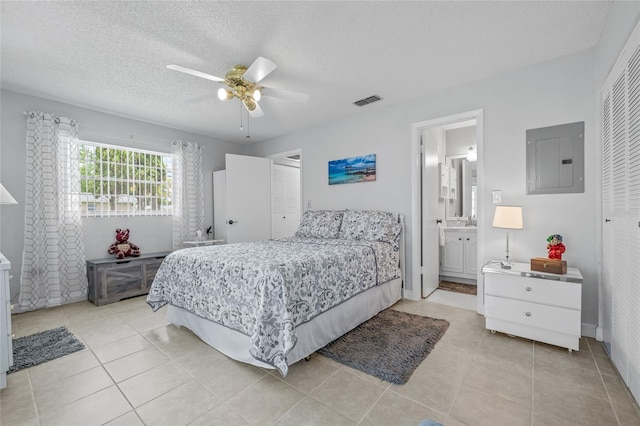 11923 Boynton Ln Unit B, New Port Richey, FL 34654 - bedroom with electric panel, light tile patterned floors, a textured ceiling, a ceiling fan, and connected bathroom