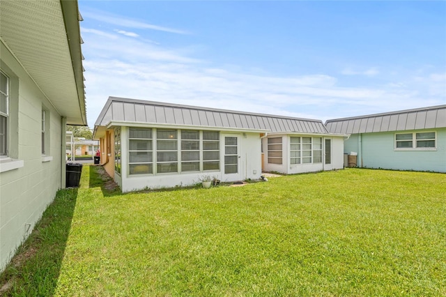 11923 Boynton Ln Unit B, New Port Richey, FL 34654 - back of property featuring a metal roof and a yard