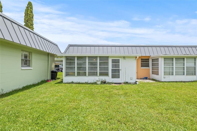 11923 Boynton Ln Unit B, New Port Richey, FL 34654 - back of house with a lawn, a metal roof, and a standing seam roof