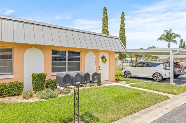 11923 Boynton Ln Unit B, New Port Richey, FL 34654 - view of front of house featuring stucco siding, a standing seam roof, a front lawn, and a metal roof