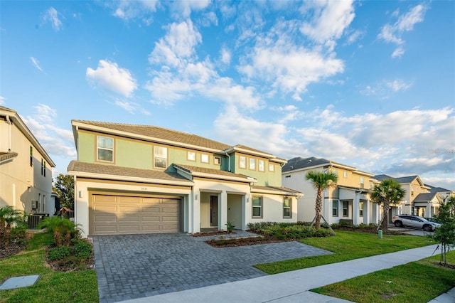 2537 Shanti Dr, Kissimmee, FL 34746 - view of front of property featuring a residential view, an attached garage, stucco siding, a front yard, and decorative driveway