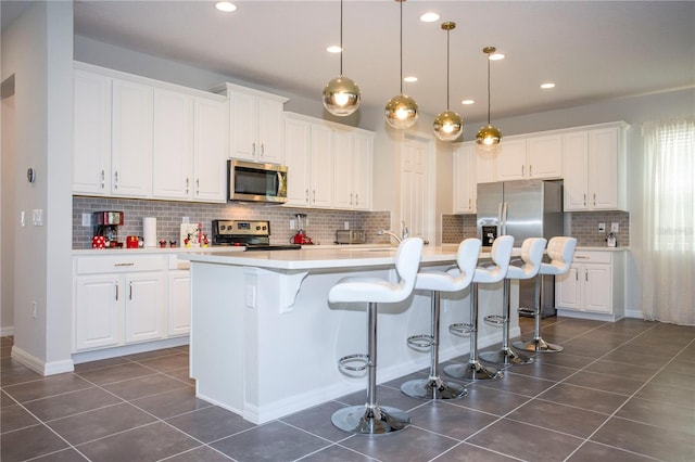 9071 Sunshine Ridge Loop, Kissimmee, FL 34747 - kitchen featuring appliances with stainless steel finishes, white cabinets, dark tile patterned flooring, tasteful backsplash, and recessed lighting