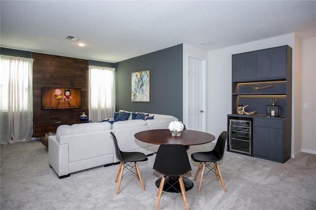 9071 Sunshine Ridge Loop, Kissimmee, FL 34747 - dining area with wine cooler, light carpet, a textured ceiling, a dry bar, and wood walls