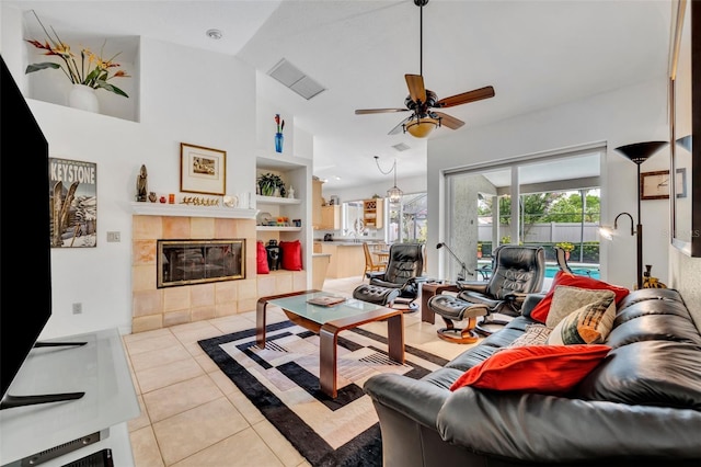 6630 Hidden Beach Cir, Orlando, FL 32819 - living area featuring built in shelves, tile patterned flooring, ceiling fan, and a tile fireplace