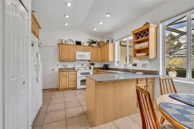 6630 Hidden Beach Cir, Orlando, FL 32819 - kitchen featuring white appliances, a peninsula, lofted ceiling, light brown cabinetry, and light tile patterned floors