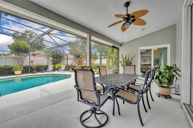 6630 Hidden Beach Cir, Orlando, FL 32819 - view of swimming pool with a patio area, a ceiling fan, outdoor dining area, and glass enclosure