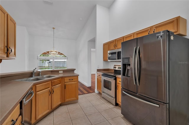 12713 Pine Arbor Dr, Clermont, FL 34711 - kitchen featuring appliances with stainless steel finishes, light tile patterned floors, a chandelier, hanging light fixtures, and high vaulted ceiling