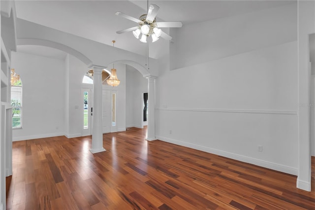 12713 Pine Arbor Dr, Clermont, FL 34711 - foyer with arched walkways, decorative columns, ceiling fan, wood finished floors, and high vaulted ceiling