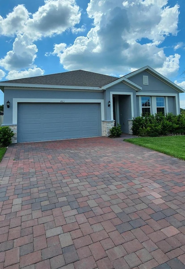 483 Shadow Gorge Way, Eustis, FL 32736 - ranch-style house featuring decorative driveway, stone siding, and stucco siding