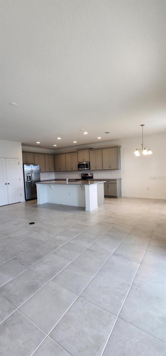 483 Shadow Gorge Way, Eustis, FL 32736 - kitchen featuring stainless steel appliances, light tile patterned floors, recessed lighting, hanging light fixtures, and a kitchen island