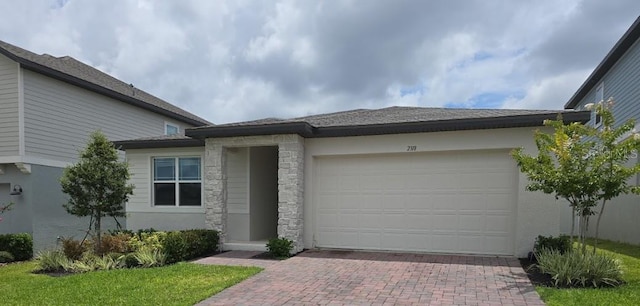 2318 Raven Ridge Rd, Minneola, FL 34715 - prairie-style home with decorative driveway, a garage, stone siding, and stucco siding