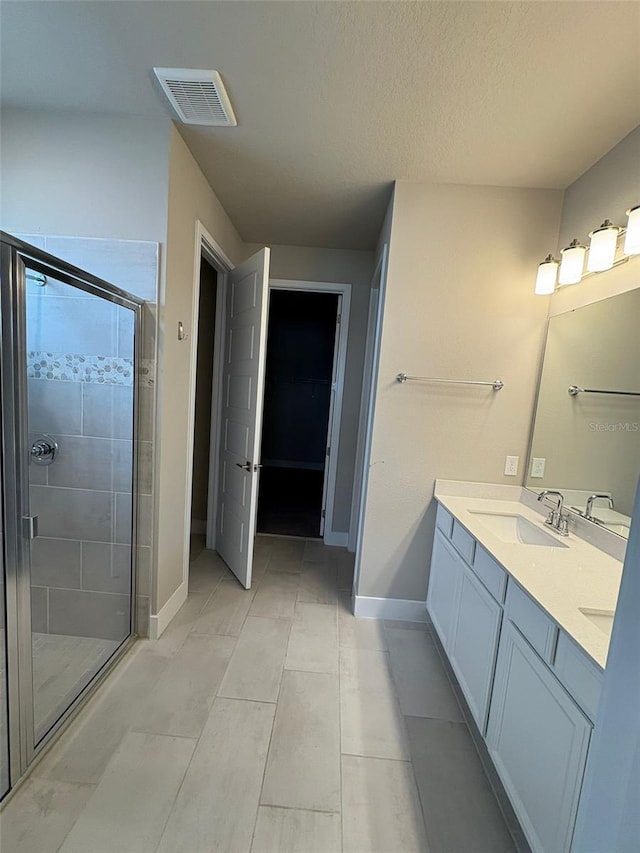 2318 Raven Ridge Rd, Minneola, FL 34715 - bathroom with a shower stall, double vanity, and a textured ceiling