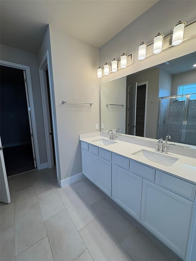 2318 Raven Ridge Rd, Minneola, FL 34715 - bathroom featuring a shower stall, double vanity, tile patterned floors, and a walk in closet
